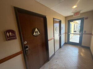 Hotel corridor with restroom signage and exit