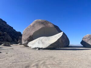 Giant curved boulder under clear blue sky
