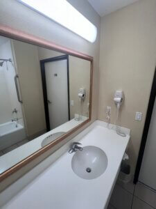 White sink countertop with wall-mounted hairdryer