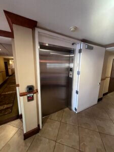 Stainless elevator door framed by beige pillars