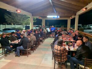 Crowded covered patio dinner under wooden roof