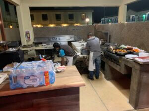 Two cooks prepping food at outdoor kitchen