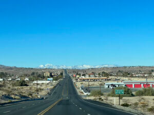 Desert highway leading to snow-capped mountains