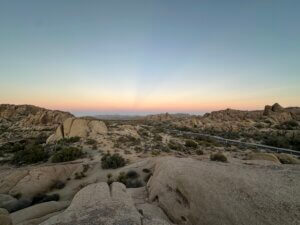 Pastel dusk sky above boulder-strewn desert road