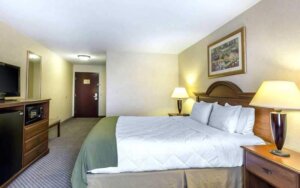 Neutral-toned motel room with TV and microwave